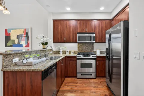 a kitchen with stainless steel appliances granite countertop a sink stove and refrigerator