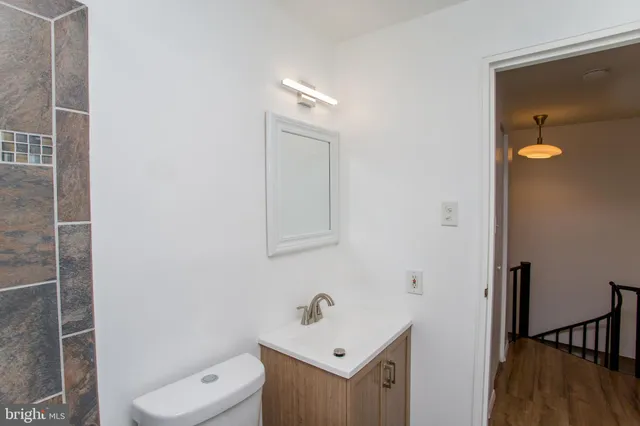 a bathroom with a toilet a sink and mirror