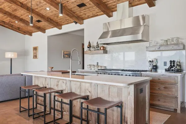 a kitchen with stainless steel appliances granite countertop a stove a sink and a refrigerator