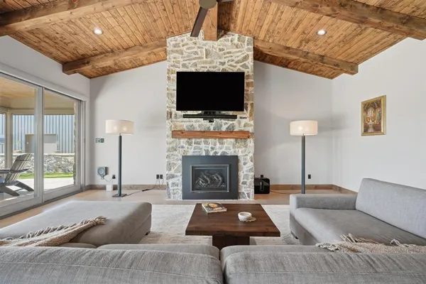 a living room with furniture a flat screen tv and a fireplace