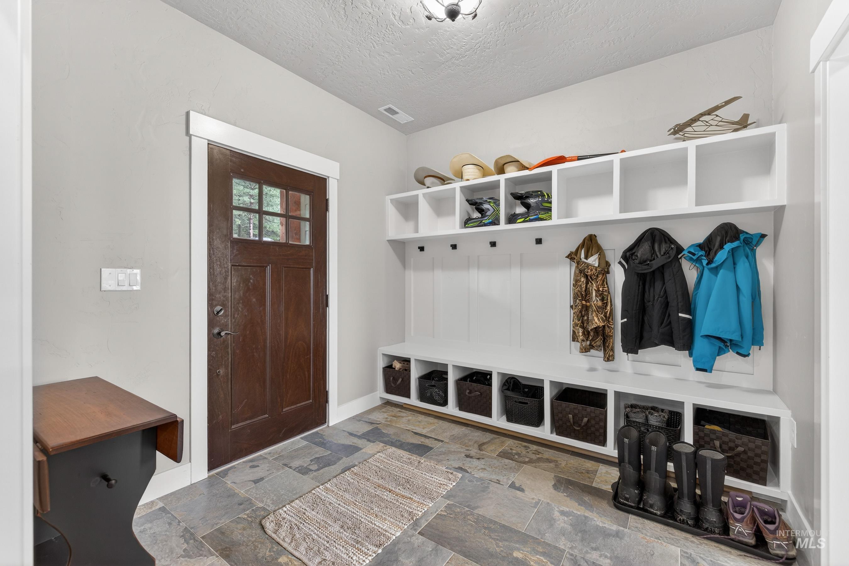 10191 Timberrim Drive Cascade, ID 83611 - Photo 10 of 44 Mudroom featuring a textured ceiling and stone tile flooring