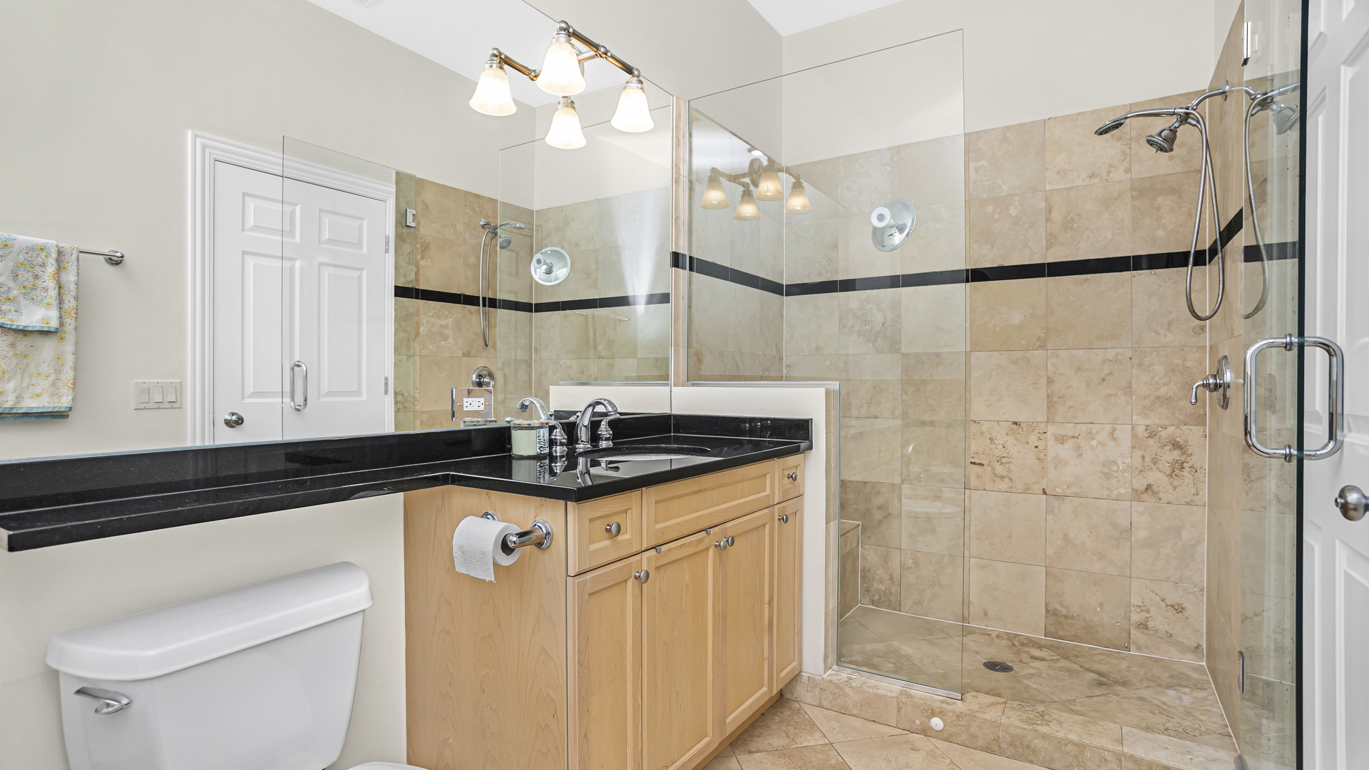 1908 West Irving Park Road, Unit 301 Chicago, IL 60613 - Photo 13 of 24 a bathroom with a granite countertop sink a mirror a shower and vanity