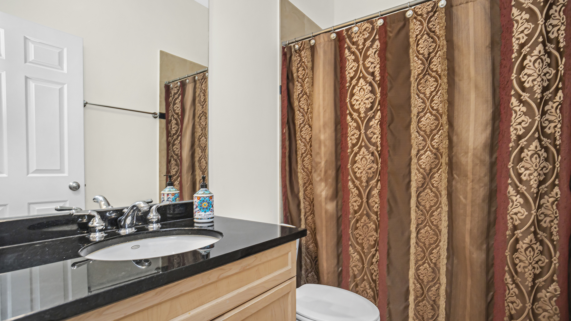 1908 West Irving Park Road, Unit 301 Chicago, IL 60613 - Photo 20 of 24 a bathroom with a granite countertop sink and a mirror