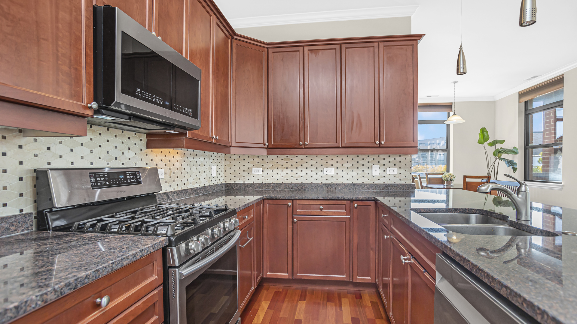 1908 West Irving Park Road, Unit 301 Chicago, IL 60613 - Photo 7 of 24 a kitchen with granite countertop wooden cabinets stainless steel appliances and a counter space
