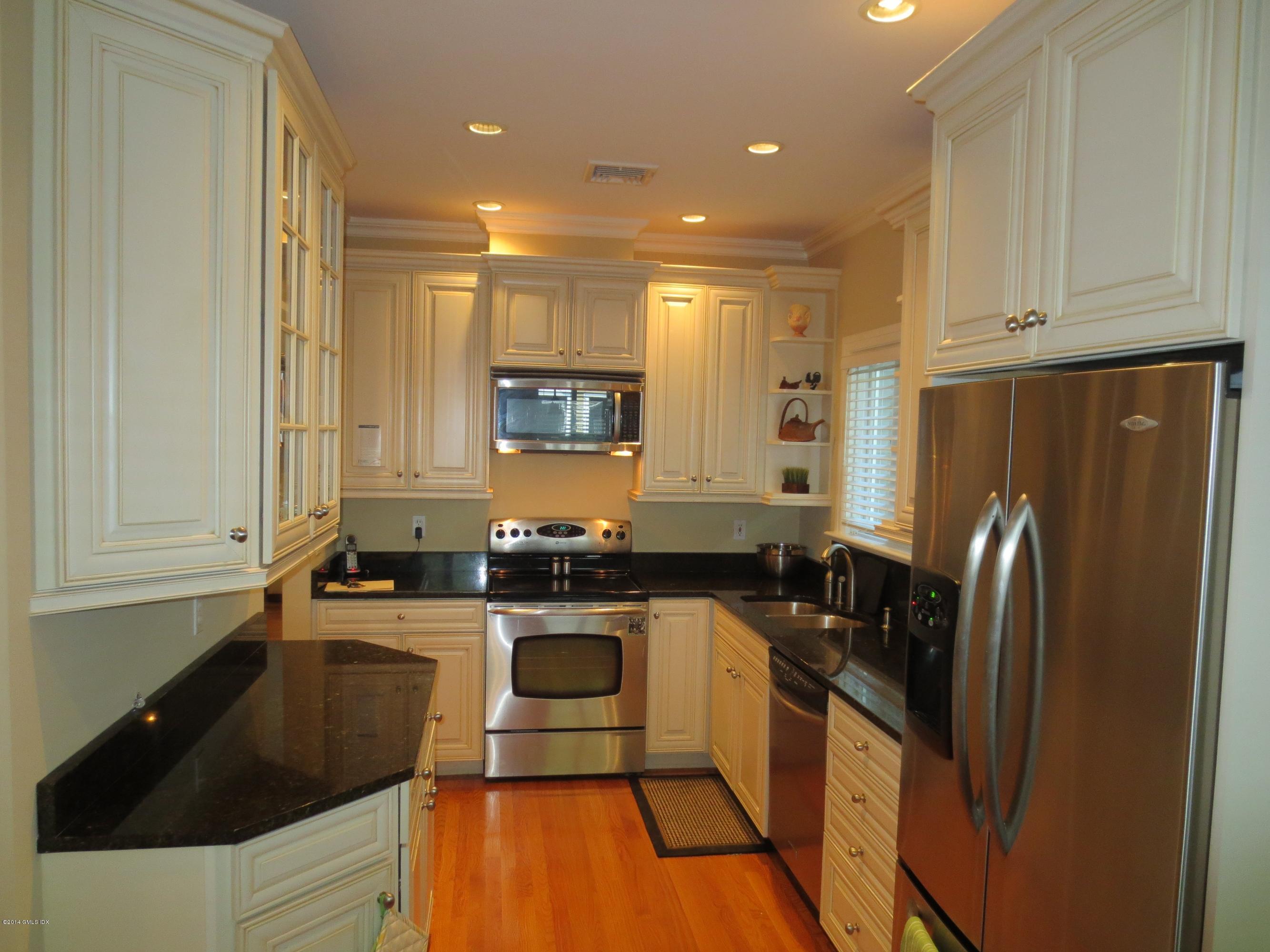 333 Palmer Hill Road, Unit 1D Riverside, CT 06878 - Photo 5 of 12 a kitchen with granite countertop a refrigerator a sink a stove a microwave and island