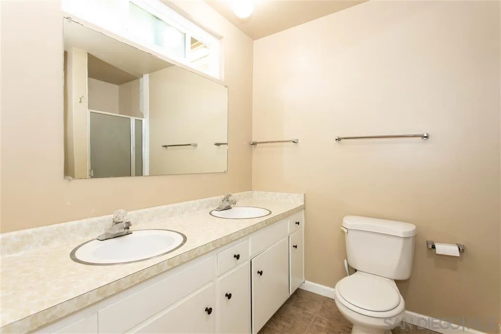 5939 Normandie Place Riverside, CA 92506 - Photo 13 of 21 a bathroom with a toilet a sink and mirror