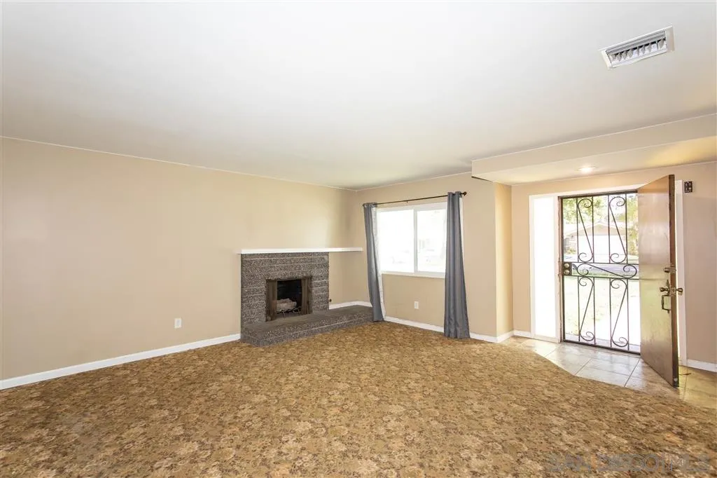 5939 Normandie Place Riverside, CA 92506 - Photo 4 of 21 an empty room with windows and fireplace