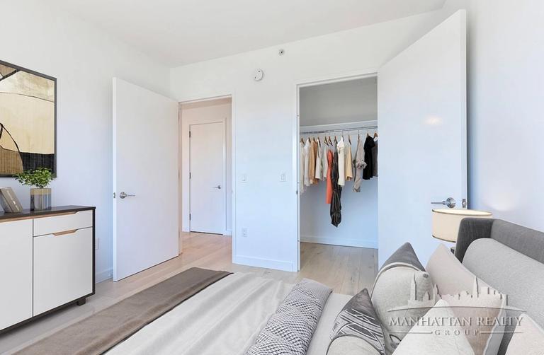 144-74 Northern Boulevard, Unit PHJ Queens, NY 11354 - Photo 3 of 13 a bedroom with a bed and a couch