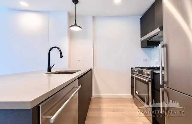 a kitchen with stainless steel appliances granite countertop a sink and a stove