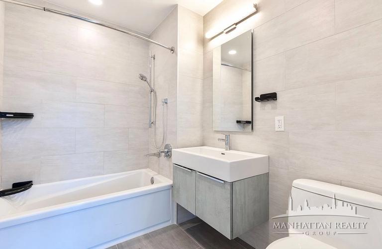144-74 Northern Boulevard, Unit PHJ Queens, NY 11354 - Photo 7 of 13 a bathroom with a sink a mirror and a bathtub