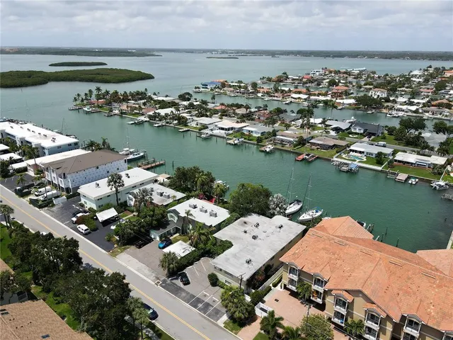an aerial view of a city with lots of residential buildings ocean and mountain view in back