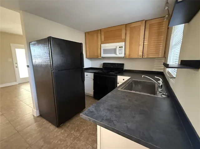 a kitchen with a refrigerator sink and cabinets