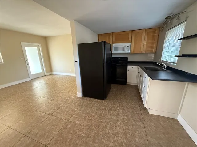 a kitchen with granite countertop a refrigerator and a stove top oven