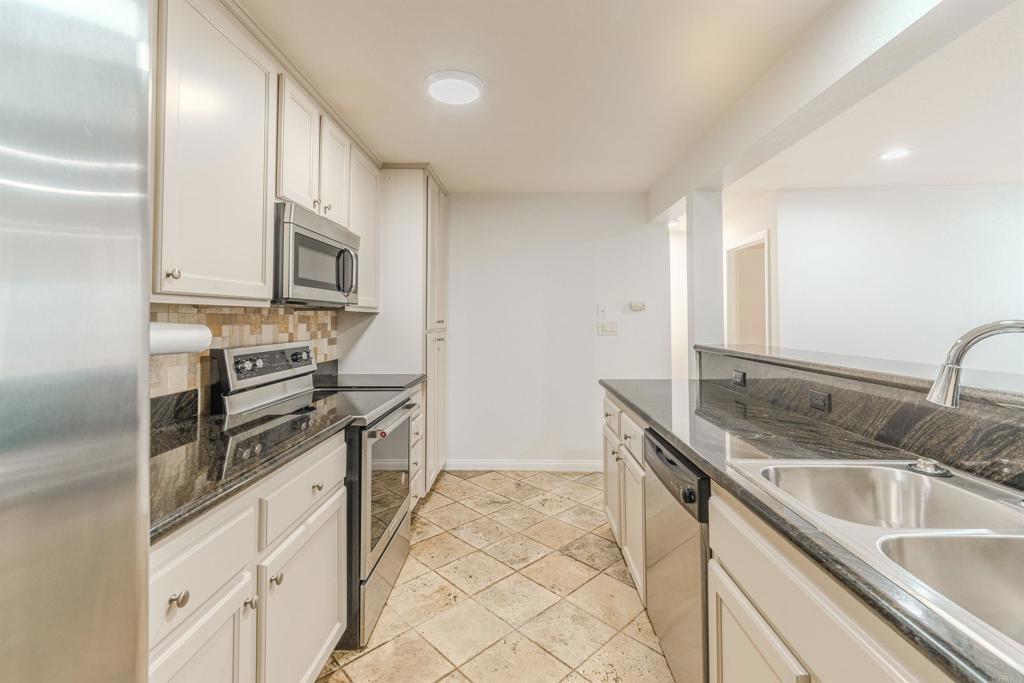 9860 Dale Avenue, Unit D10 Spring Valley, CA 91977 - Photo 13 of 55 a kitchen with stainless steel appliances granite countertop a sink stove and microwave