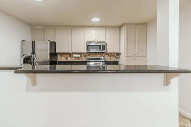 a kitchen with granite countertop a stove microwave and sink