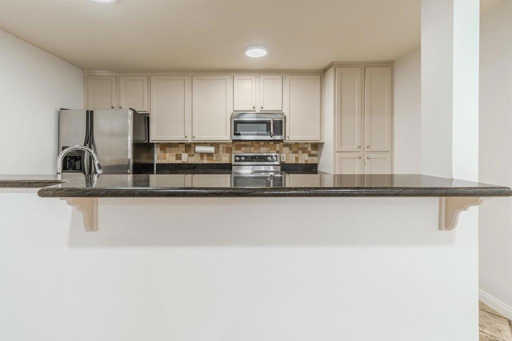 9860 Dale Avenue, Unit D10 Spring Valley, CA 91977 - Photo 9 of 55 a kitchen with kitchen island a sink stainless steel appliances and cabinets