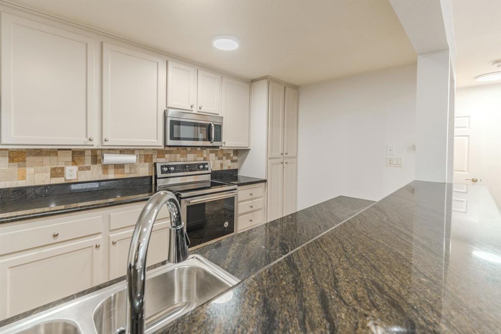 9860 Dale Avenue, Unit D10 Spring Valley, CA 91977 - Photo 10 of 55 a kitchen with granite countertop a stove microwave and sink
