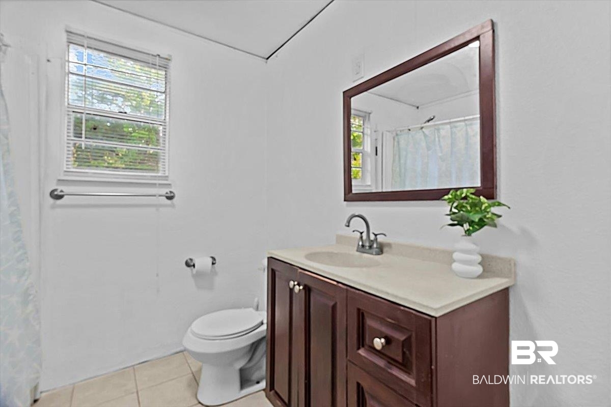4918 Quimby Drive Mobile, AL 36619 - Photo 27 of 38 Full bathroom with vanity, tile patterned floors, toilet, and healthy amount of natural light