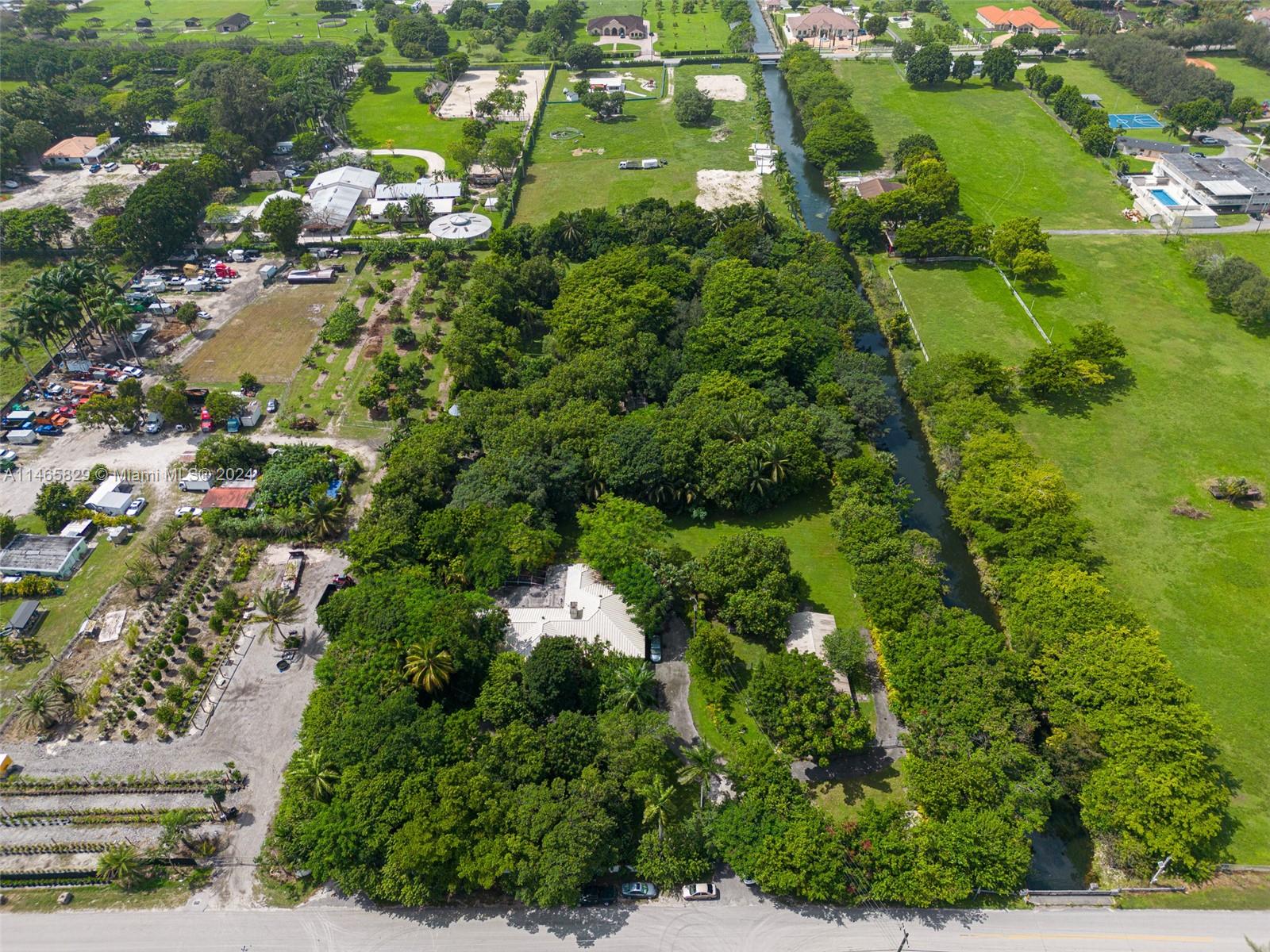 an aerial view of residential houses with outdoor space and trees