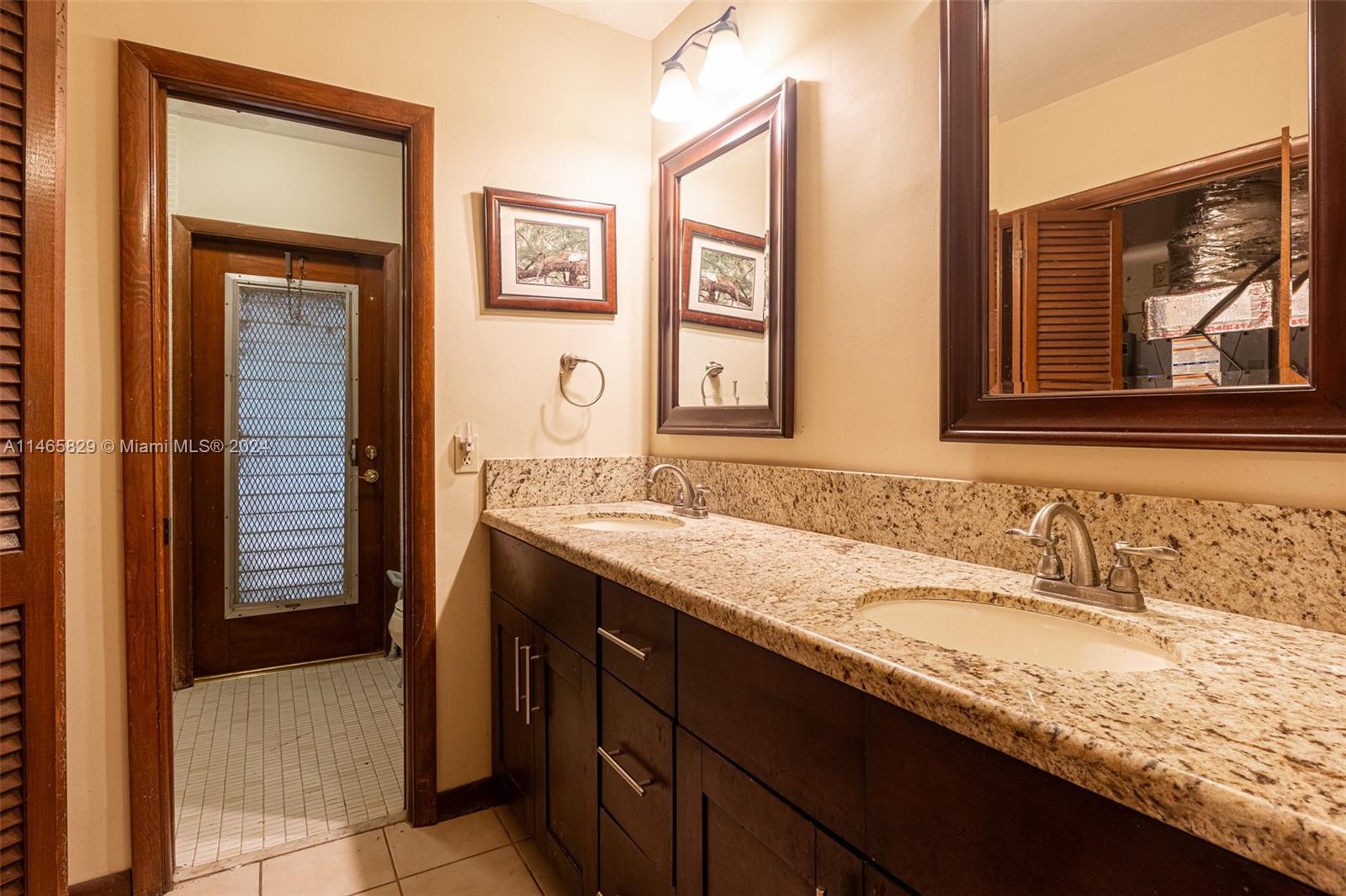 6000 Southwest 118th Avenue Miami, FL 33183 - Photo 25 of 49 a bathroom with a granite countertop sink and a mirror