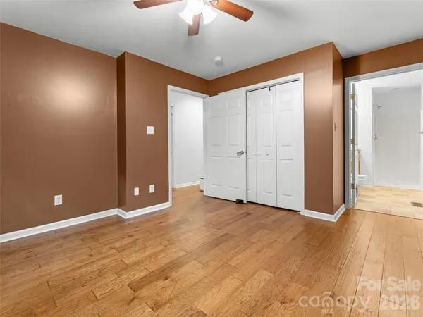 a view of an empty room with a chandelier fan
