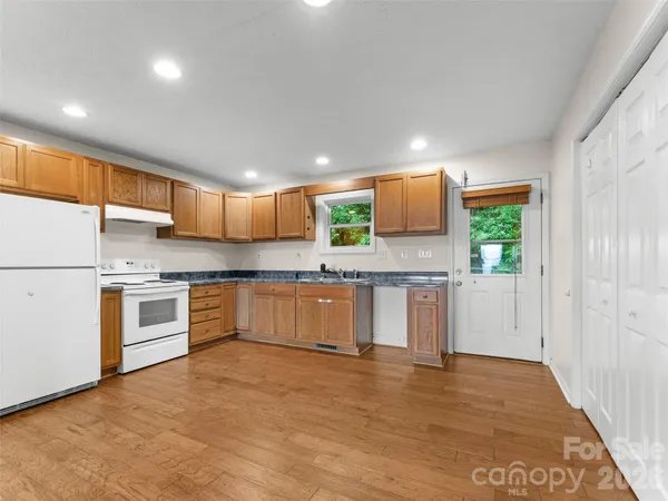 a large kitchen with stainless steel appliances granite countertop a large counter top and a stove top oven