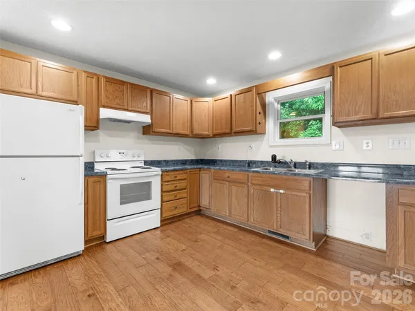 a kitchen with granite countertop white cabinets and white appliances