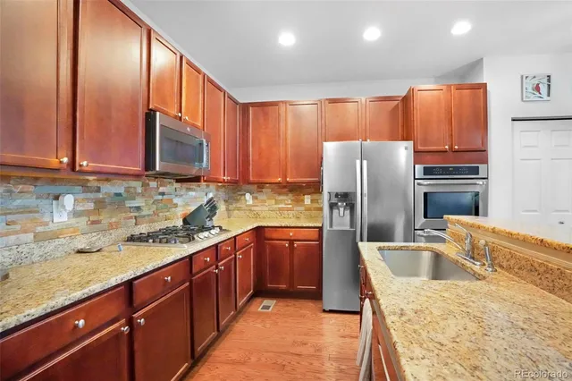 a kitchen with stainless steel appliances granite countertop a sink refrigerator and microwave