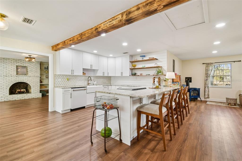 3009 Jim Johnson Road Plant City, FL 33566 - Photo 12 of 84 a kitchen with stainless steel appliances a table chairs refrigerator microwave and cabinets