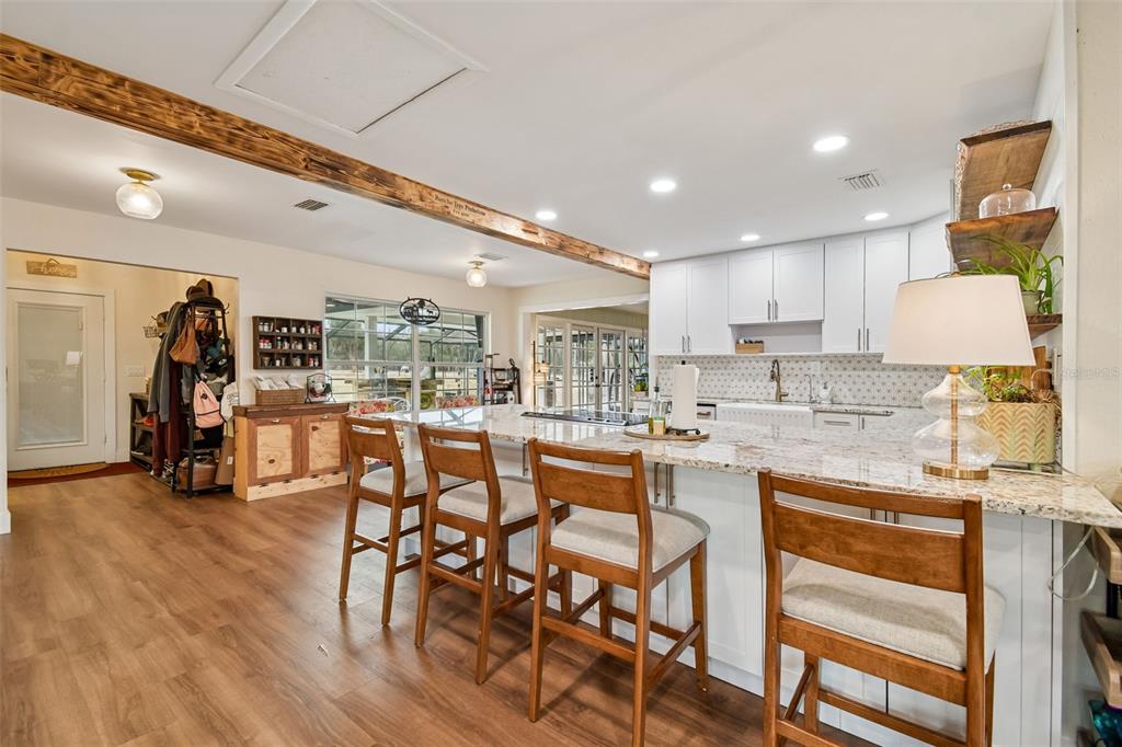 3009 Jim Johnson Road Plant City, FL 33566 - Photo 21 of 84 a kitchen with stainless steel appliances kitchen island granite countertop a table chairs in it and white cabinets