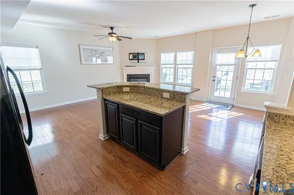 a kitchen with a stove and wooden floor