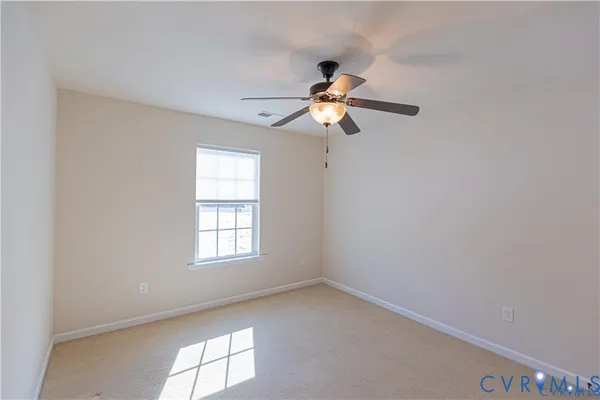 an empty room with window and ceiling fan