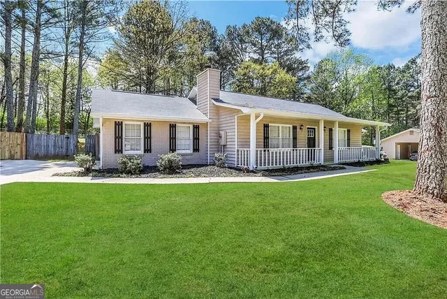 a view of a house with a yard patio and fire pit