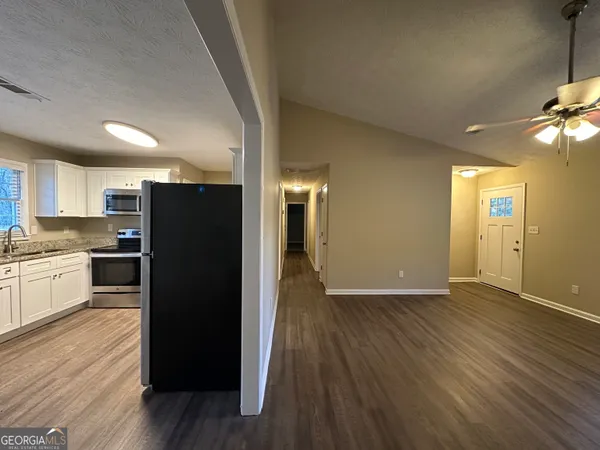 a kitchen with a refrigerator and a stove top oven