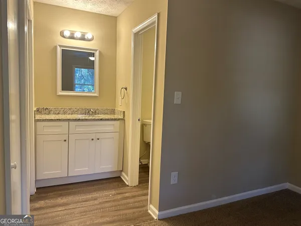 an empty room with wooden floor and cabinet