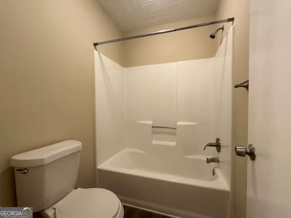 a white toilet sitting next to a bath tub