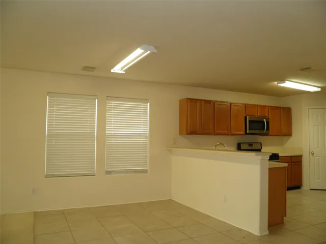 an empty room with windows and fireplace