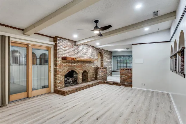 a view of a livingroom with wooden floor a fireplace