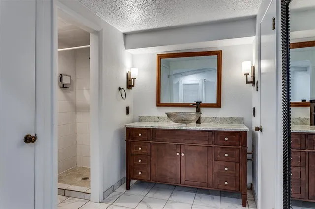 a bathroom with a granite countertop sink a toilet and a mirror