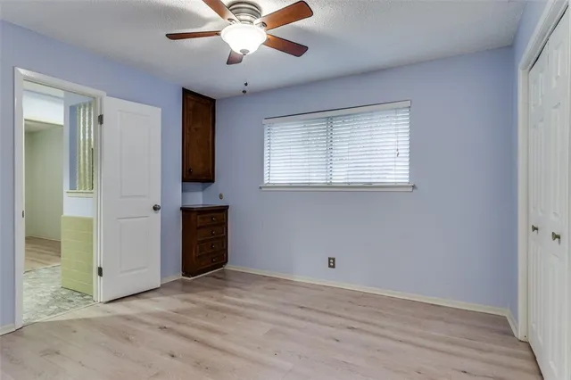 an empty room with a ceiling fan and a window