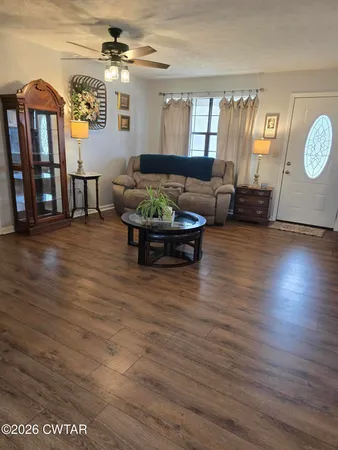a living room with furniture and wooden floor