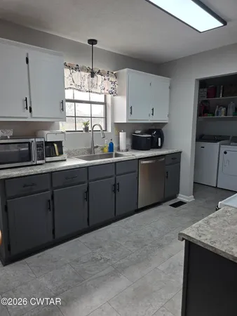 a kitchen with stainless steel appliances granite countertop a sink window and cabinets