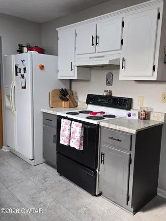 a kitchen with stainless steel appliances a stove a refrigerator and cabinets