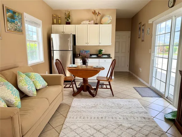 a living room with furniture and a refrigerator