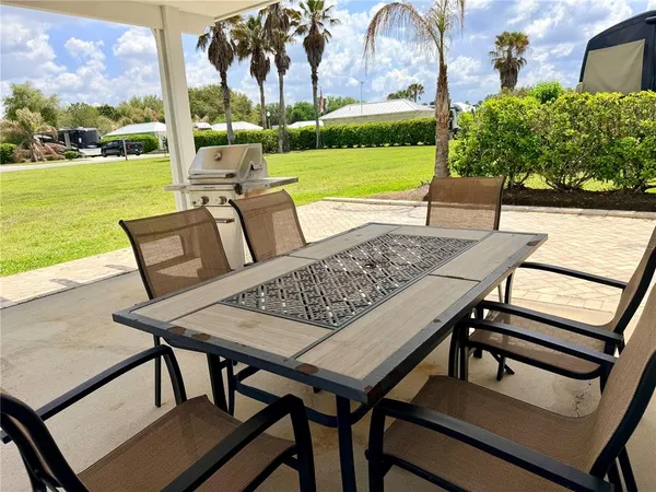 a view of a patio with lawn chairs next to a yard
