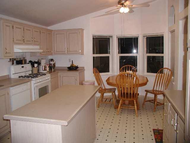796 County Road, Unit 259 Rifle, CO 81650 - Photo 2 of 8 a kitchen with a dining table chairs and a refrigerator