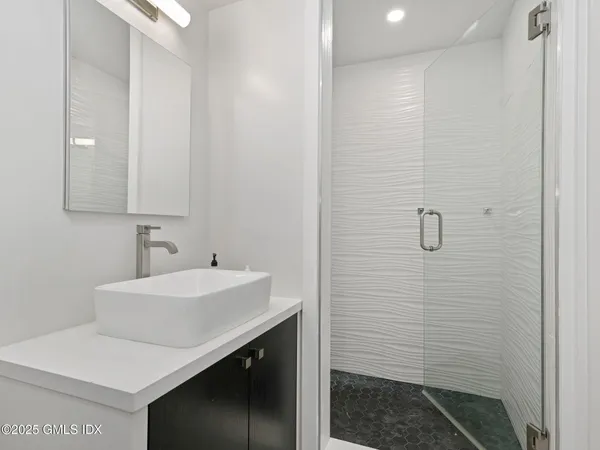 a bathroom with a sink a toilet and shower