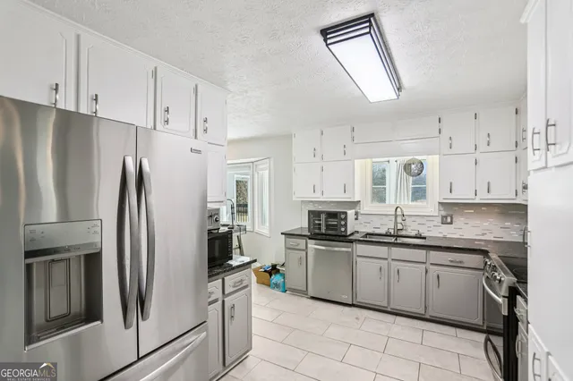 a kitchen with stainless steel appliances a refrigerator sink and cabinets