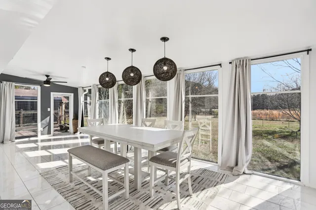 a view of a room with a large window and seating space