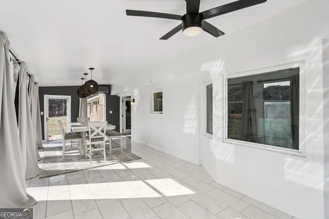 a view of a livingroom with a dinning area hardwood floor and a ceiling fan